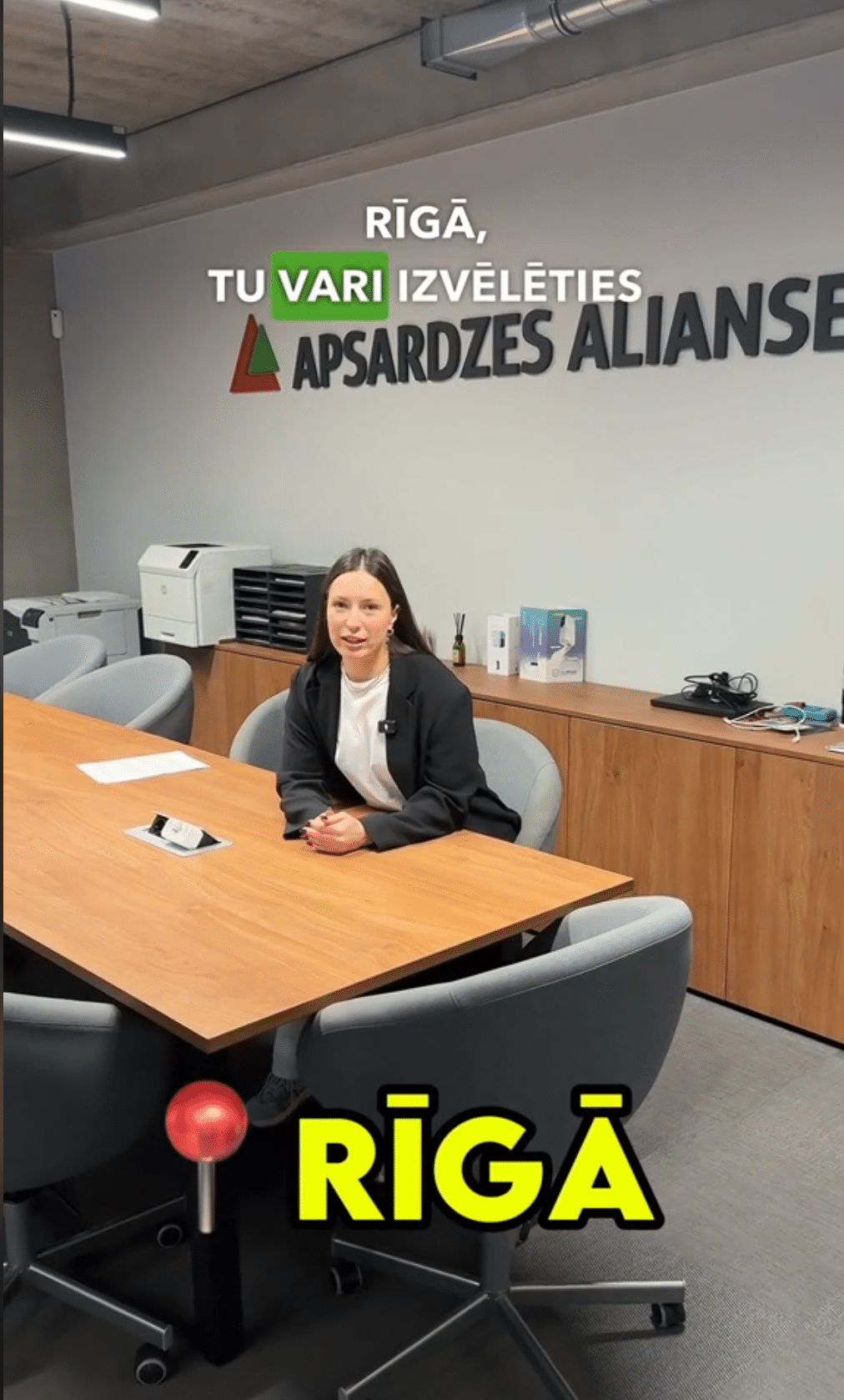 Sieviete pie darba galda apsardzes alianse uzraksts fonā